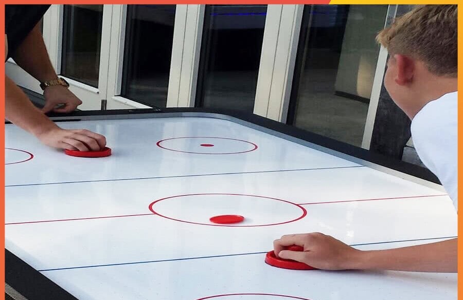 Two persons playing on Air Hockey table