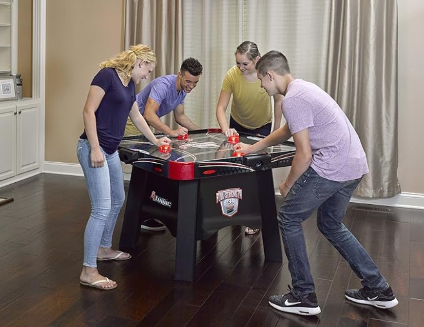 Four persons playing on Atomic Full Strength 4-player Air Hockey Table