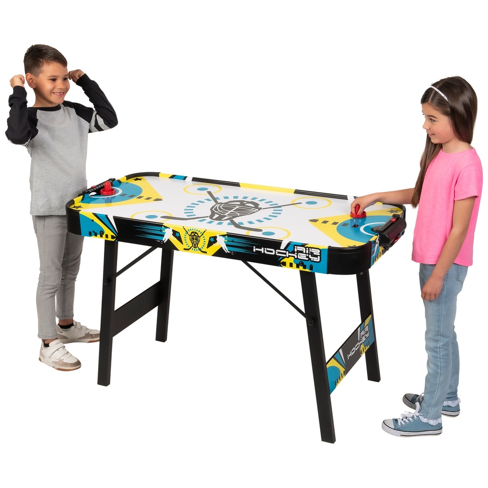 Two kids playing on air hockey table