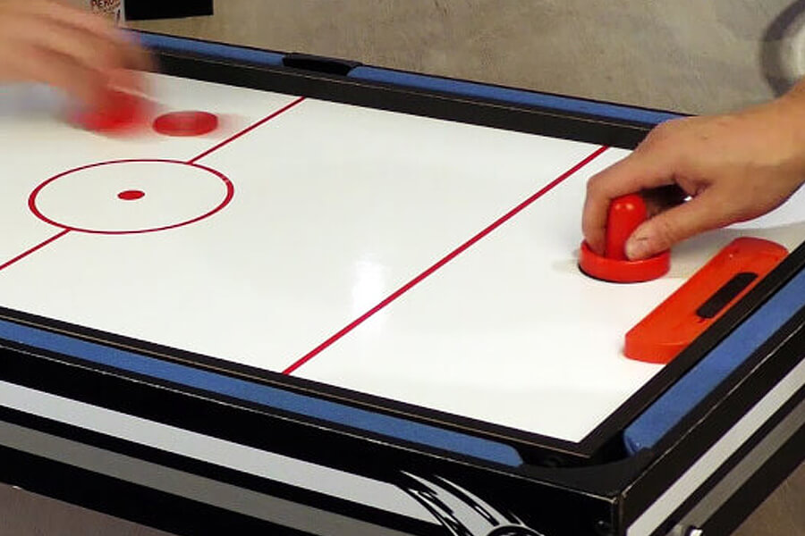 People playing on air hockey table